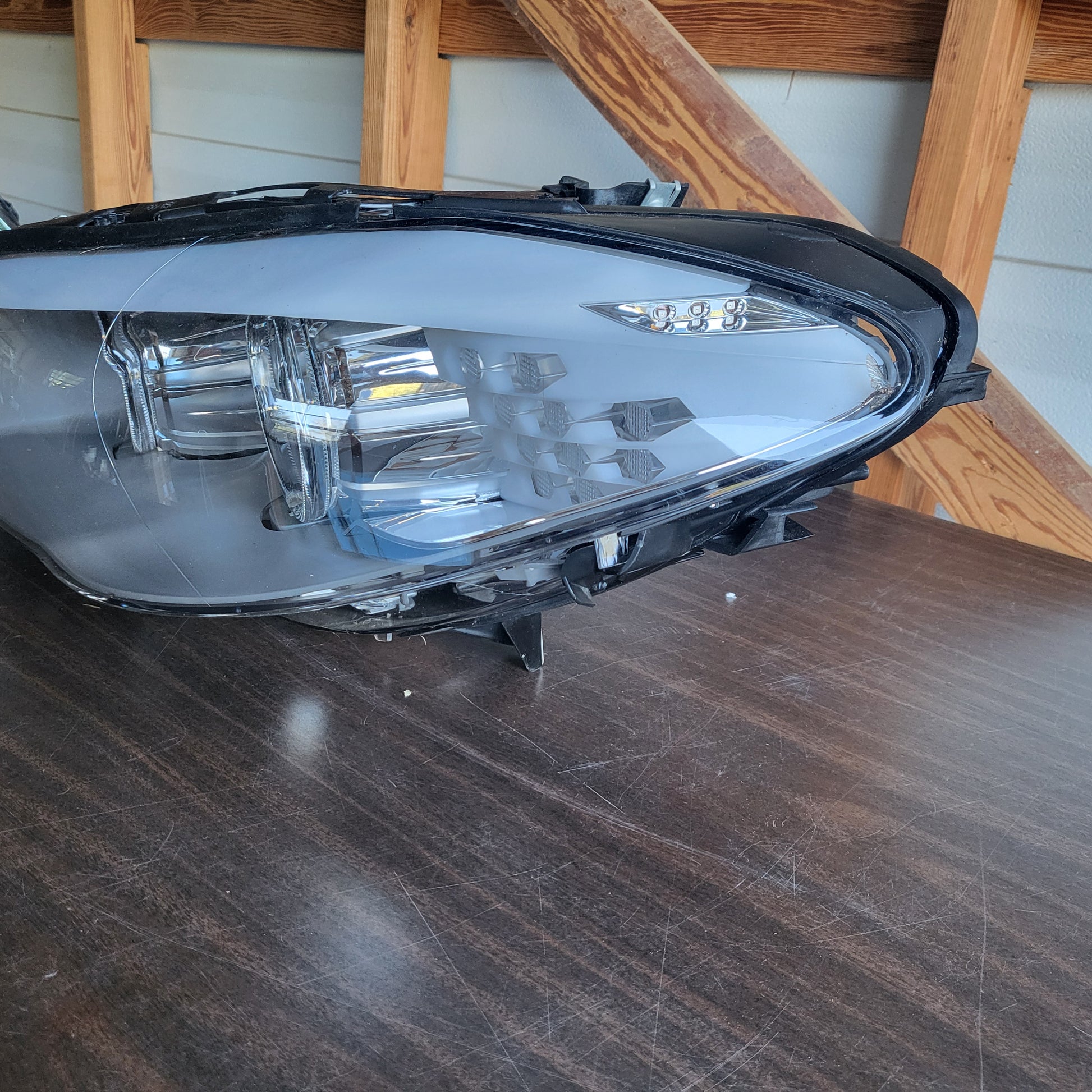 Secondhand Readers Hella Bi-Xenon headlight assembly for 2011-2013 BMW F10 5 Series driver side, left headlight showing clear lens and components.