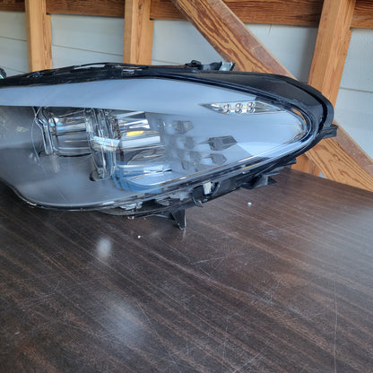 Secondhand Readers Hella Bi-Xenon headlight assembly for 2011-2013 BMW F10 5 Series driver side, left headlight showing clear lens and components.
