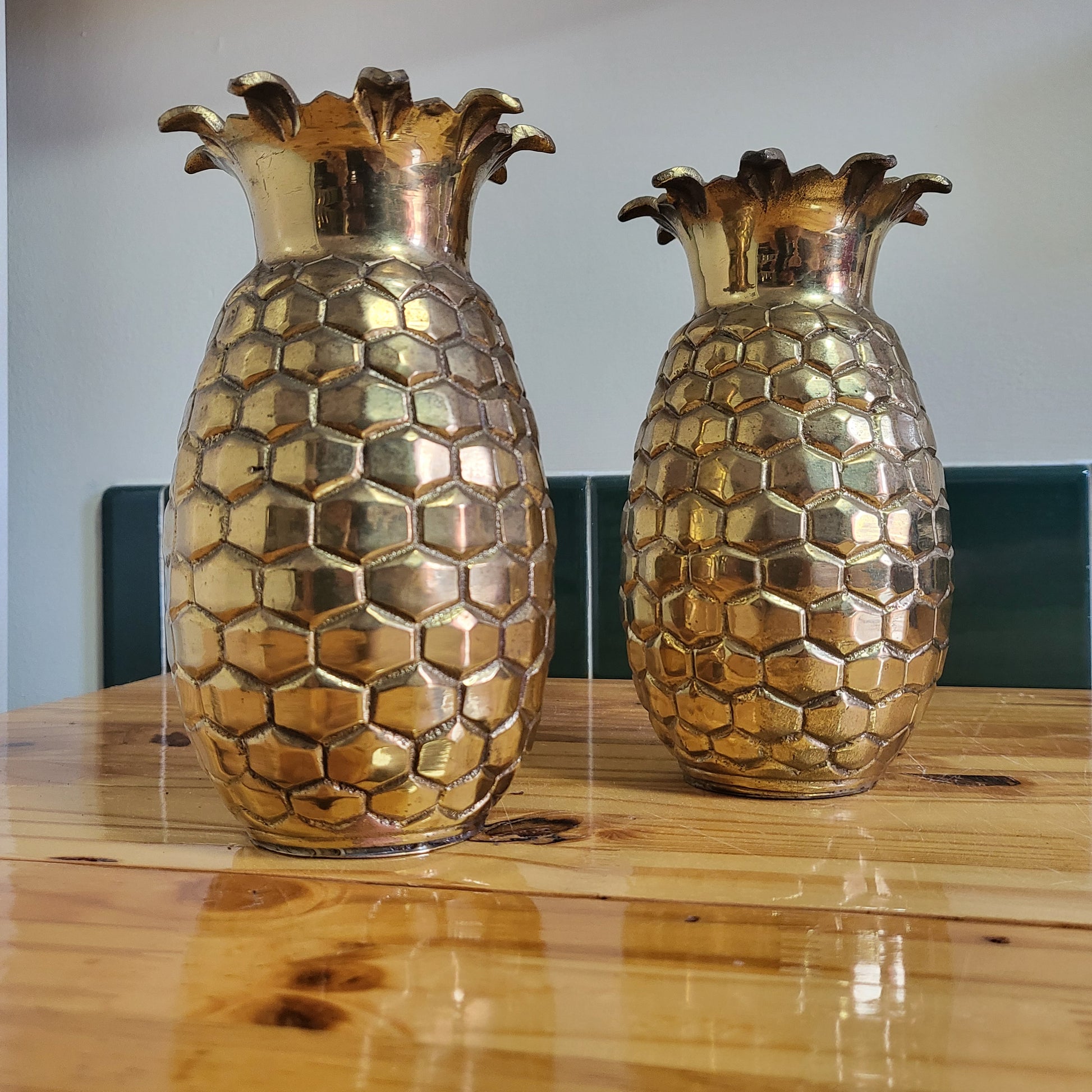 Vintage brass pineapple vases in Hollywood Regency style, 2-piece set with ornate detailing and shiny gold finish.